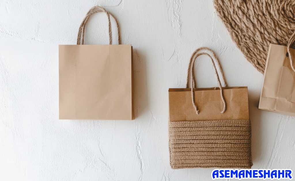 ساک های دستی کرافت با طراحی طبیعی و دسته طنابی روی دیوار سفید | مناسب برای هدیه و بسته‌ بندی سازگار با محیط زیست.