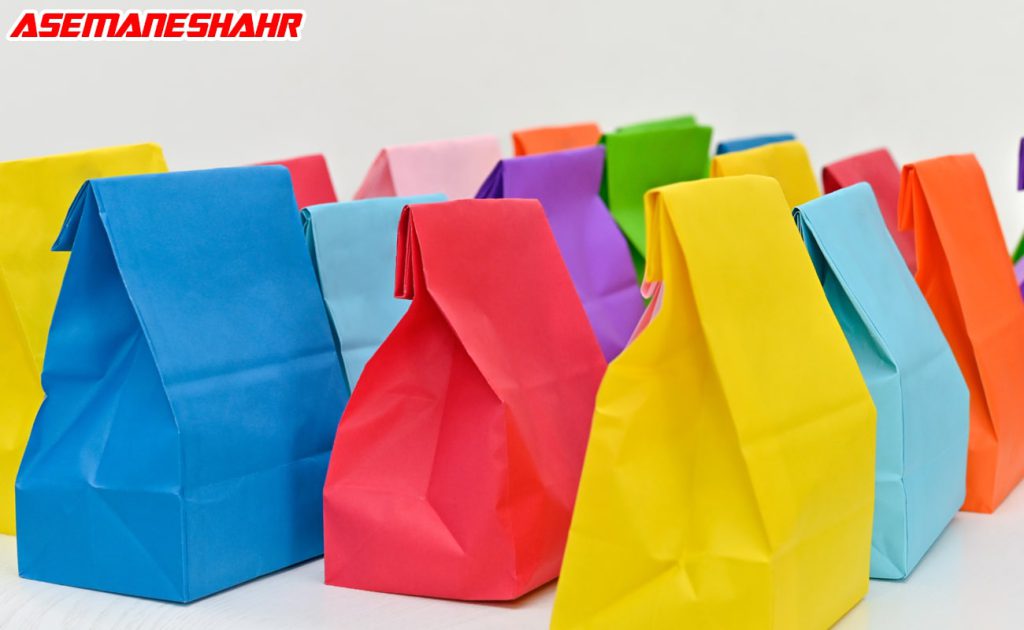مجموعه‌ ای از پاکت‌ های کاغذی رنگارنگ در رنگ‌های زرد، آبی، قرمز، نارنجی، سبز و بنفش با طراحی ساده، چیده شده روی سطح سفید با پس‌ زمینه روشن.