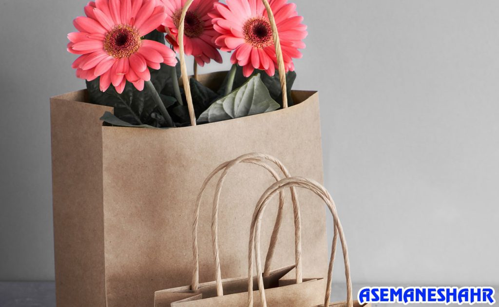 ساک دستی کاغذی کرافت پر از گل‌های صورتی تازه | ایده‌آل برای هدیه دادن و ایجاد حس خوب با بسته‌ بندی طبیعی.