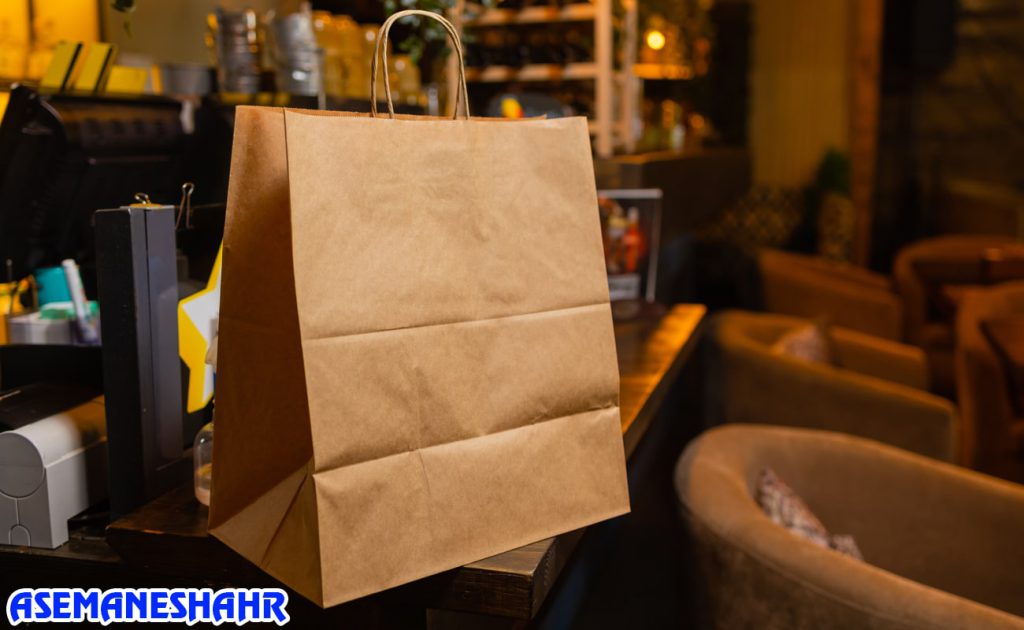ساک دستی کرافت ساده در فضای کافی‌ شاپ با نور گرم | انتخابی خاص برای بسته‌ بندی هدیه و خرید روزمره.