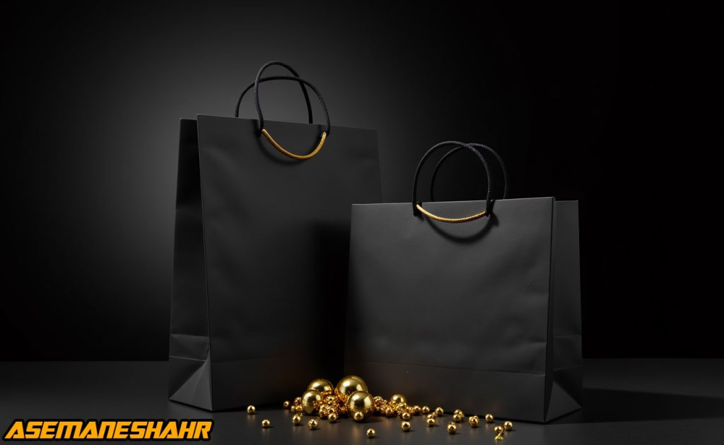 دو ساک دستی مشکی با دسته‌ های طلایی در کنار تزئینات طلایی | یک انتخاب لوکس و شیک برای بسته‌ بندی هدایا، با پس‌ زمینه‌ ای مشکی.