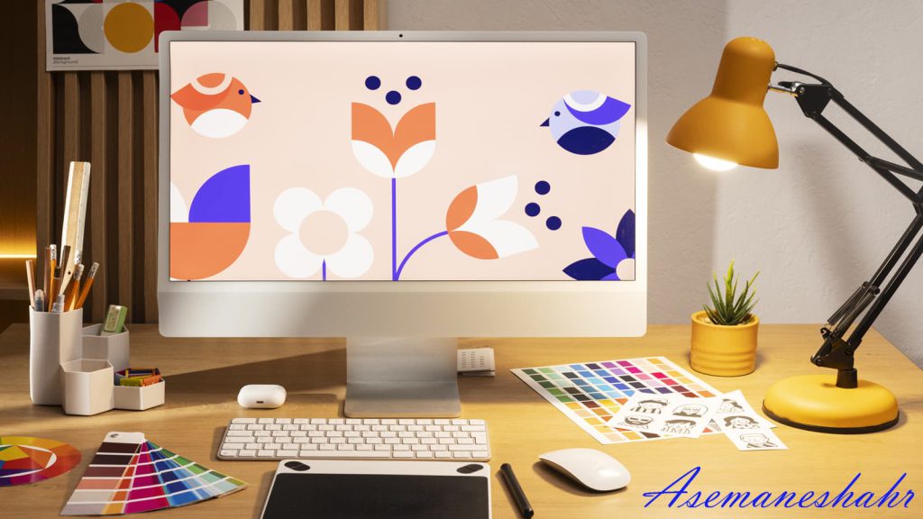 میز کار خلاقانه با مانیتور، ابزار طراحی و چراغ مطالعه زرد.