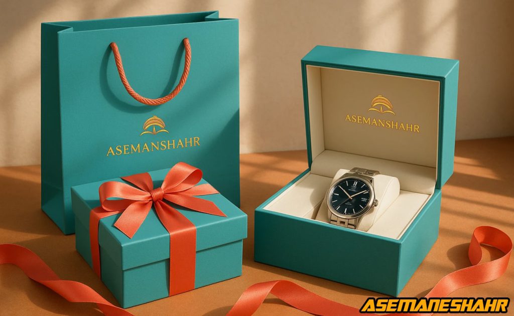جعبه ساعت لوکس با طراحی فیروزه‌ ای و روبان مرجانی در کنار ساک هدیه آسمان شهر، نمایش بسته‌ بندی حرفه‌ ای و ظرافت هدایای پریمیوم.