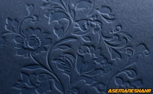 نمای نزدیک از خدمات برجسته‌ سازی روی مقوای بافت‌ دار سرمه‌ ای با طرح گل اسلیمی برای بسته‌ بندی لوکس.